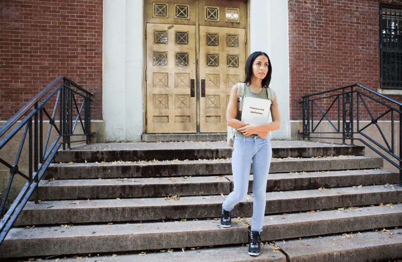student walking out of campus with a fafsa application