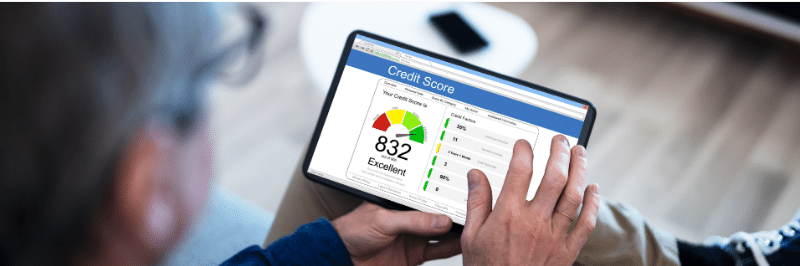 A person looking at their credit score to see how their debt to income ratio affects it